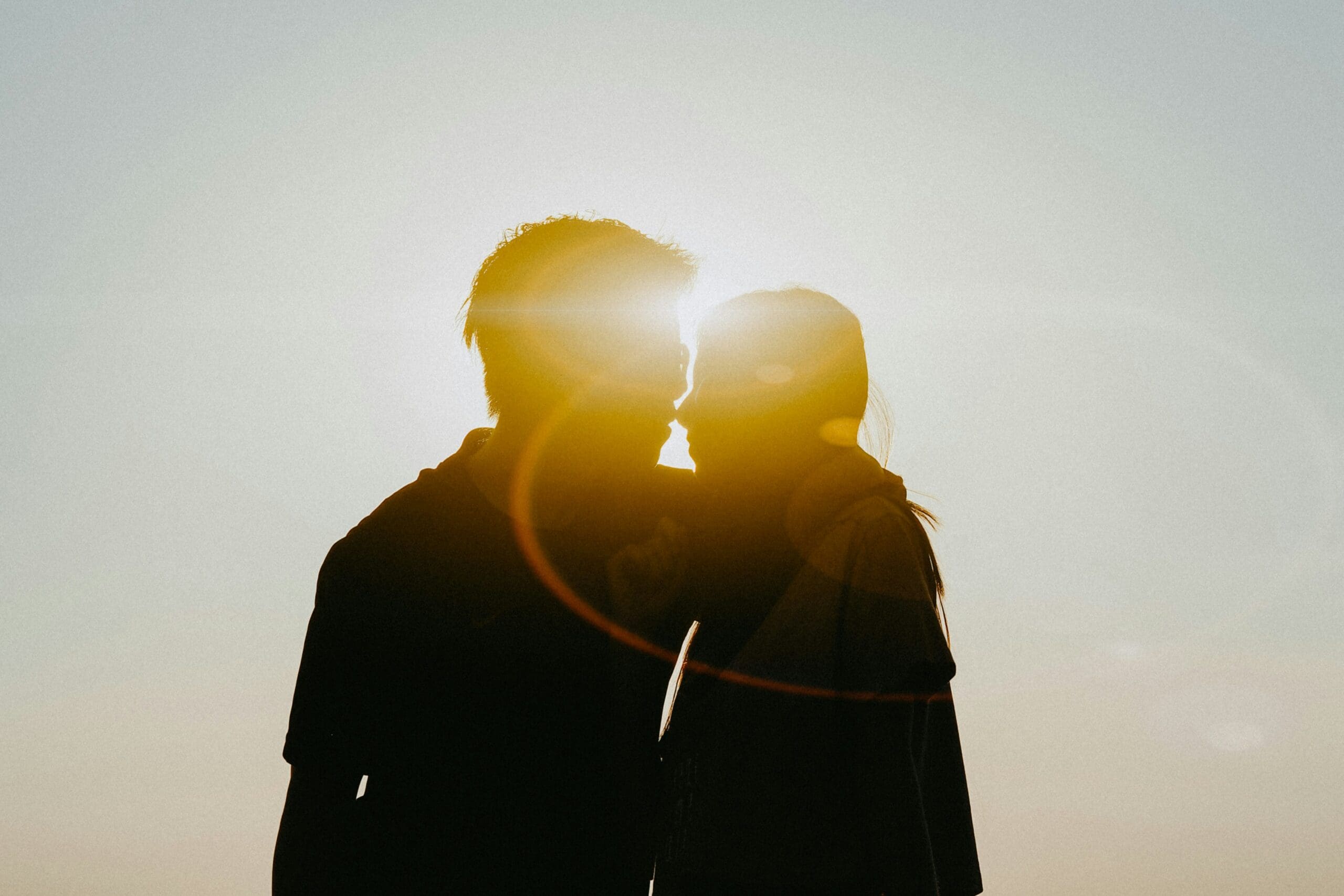 Couple facing the sun together, sharing a small moment of connection